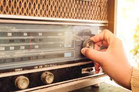 person tuning a vintage radio