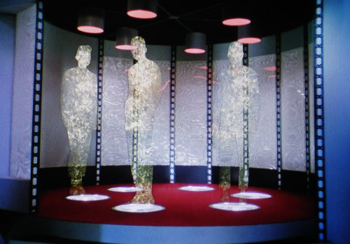 three figures in the middle of being transported on the original Star Trek TV series